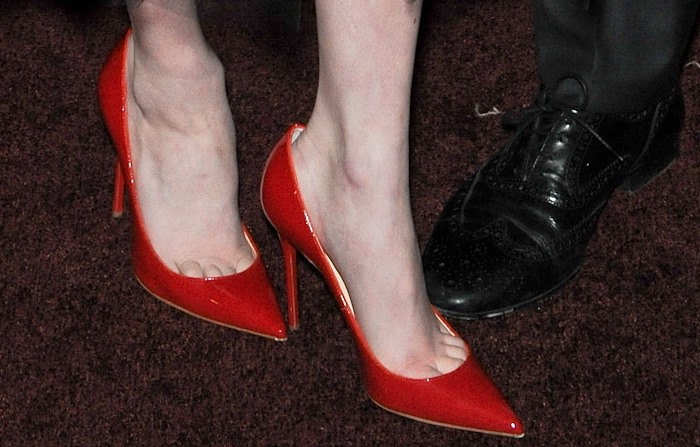 Emma Roberts’ vibrant red Christian Louboutin 'Decollete' pointed-toe pumps, showcasing her subtle nude pedicure with a hint of toe cleavage