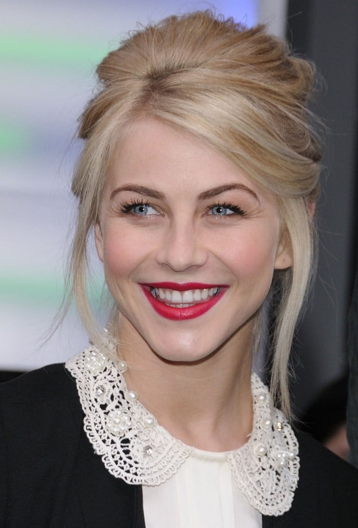 Julianne Hough flashes a bright smile in a pearl-embellished ASOS blouse paired with a polished updo and bold red lipstick