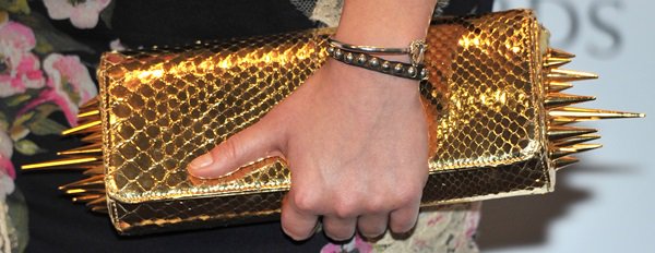 Juno Temple totes a a bold gold spiked Christian Louboutin clutch