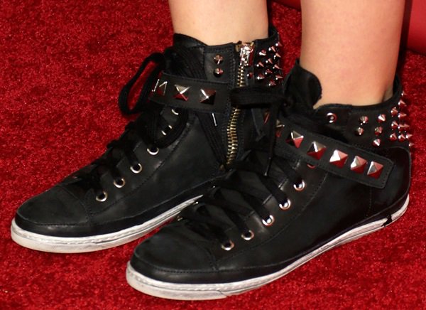 Katharine McPhee gives her red-carpet look an unexpected edge in black high-top sneakers detailed with silver pyramid studs, spikes, buckled straps, and side zippers