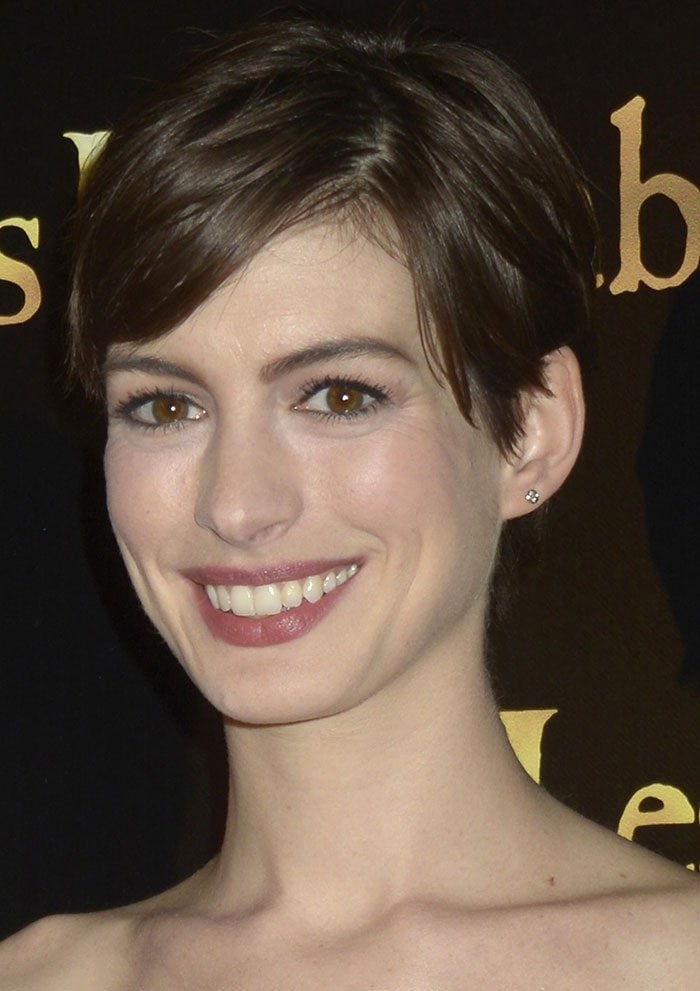 Anne Hathaway, who clipped her hair for her role in "Les Miserables," shows off her still-short pixie cut at the Paris premiere of the film