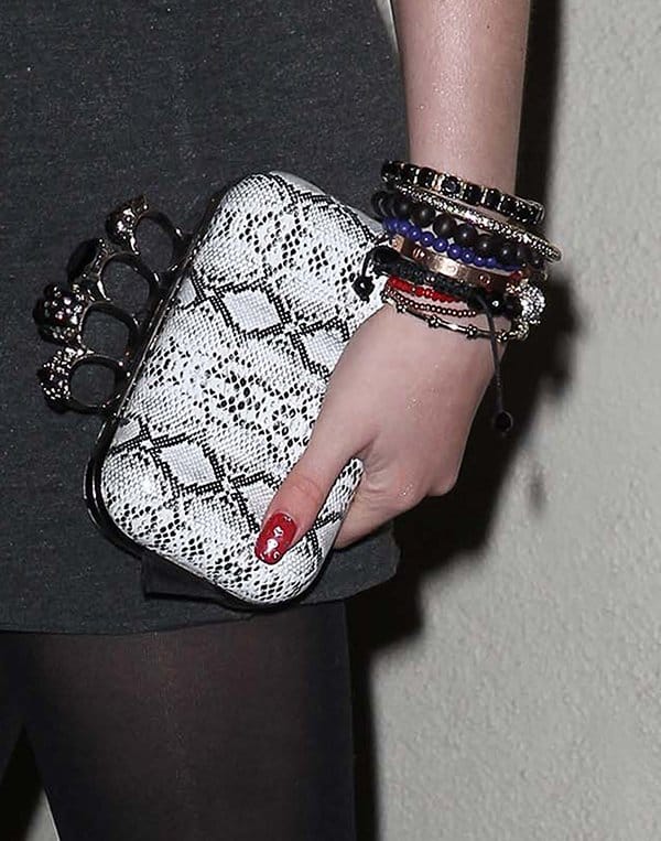 Bella Thorne’s Alexander McQueen knuckle box clutch in black-and-white python adds a bold, rocker-chic edge to her minimalist outfit