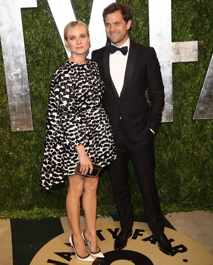Actress Diane Kruger, wearing a monochrome Giambattista Valli Spring 2013 cape dress paired with Christian Louboutin 'Paulina' pumps, poses with Joshua Jackson at the 2013 Vanity Fair Oscar Party hosted by Graydon Carter at Sunset Tower on February 24, 2013, in West Hollywood, California