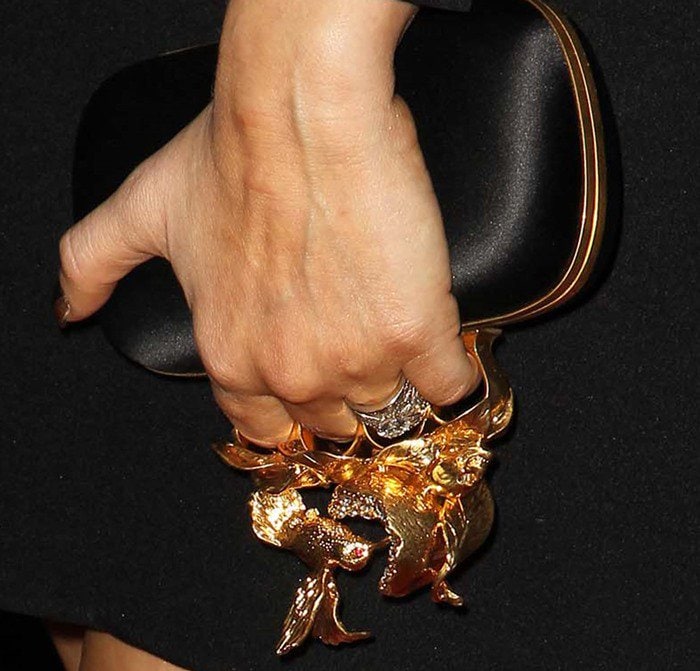 Fergie accessorizes with an eye-catching Alexander McQueen clutch featuring a bold, gold knuckle-ring handle