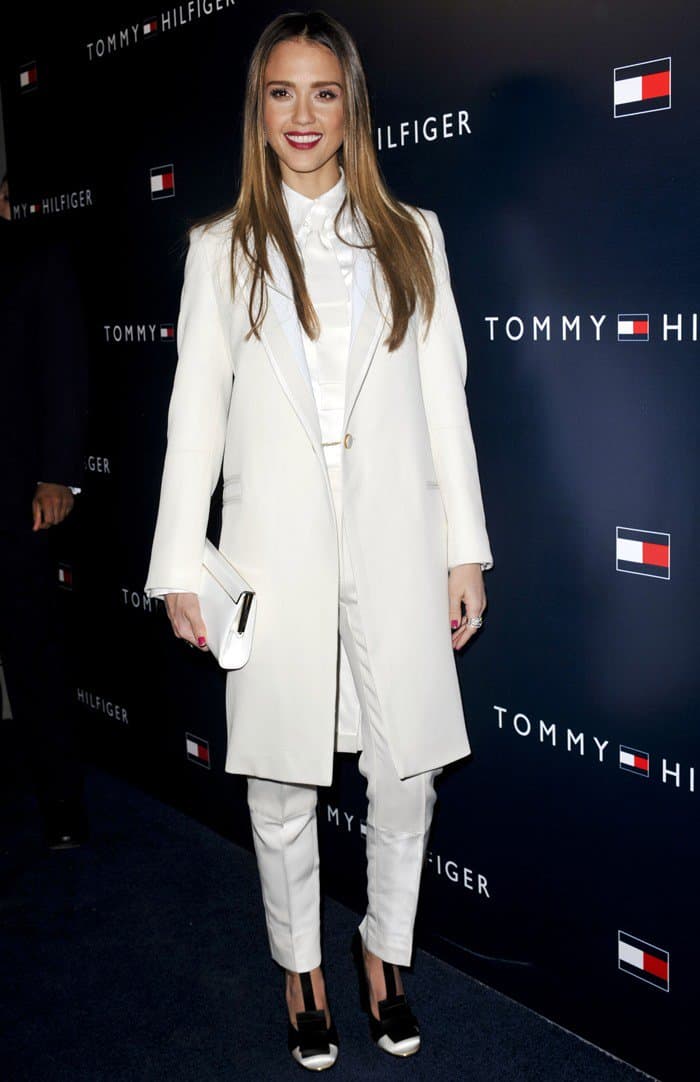 Jessica Alba keeps winter white sharp and modern in a tailored Tommy Hilfiger suit, accessorizing with a Jimmy Choo Cayla clutch, Graziella Blaike’s Double Infinity ring, Melinda Maria Single Pyramid Drop earrings, and black-and-white Tommy Hilfiger pumps for a clean, graphic finish