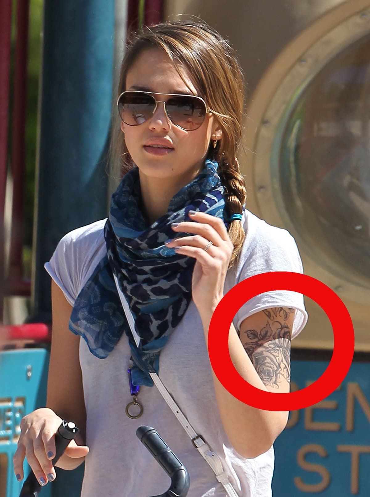 Jessica Alba shows off a large temporary floral tattoo on her arm while filming a new movie role in 2012, pairing the look with casual streetwear and oversized sunglasses
