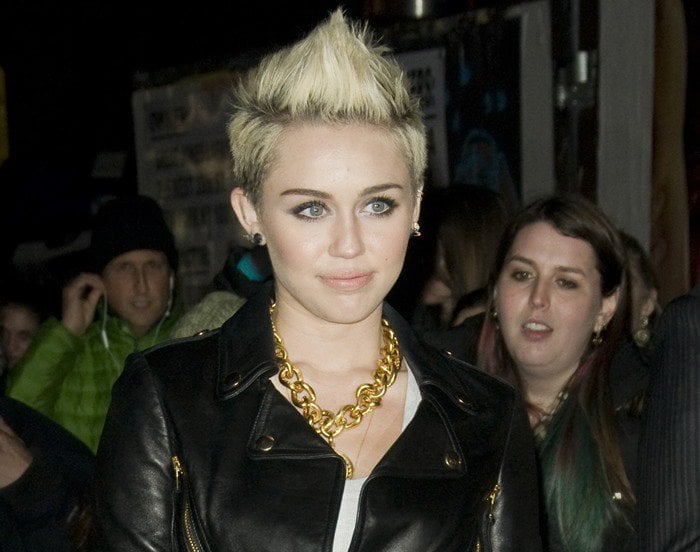 Miley Cyrus wears a statement necklace and a black Moschino Cheap Chic leather jacket