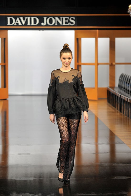 Miranda Kerr in a Zimmermann Spring 2013 lace jumpsuit, finishing the sheer, romantic look with classic black pumps that keep the long lines clean as she walks the David Jones runway