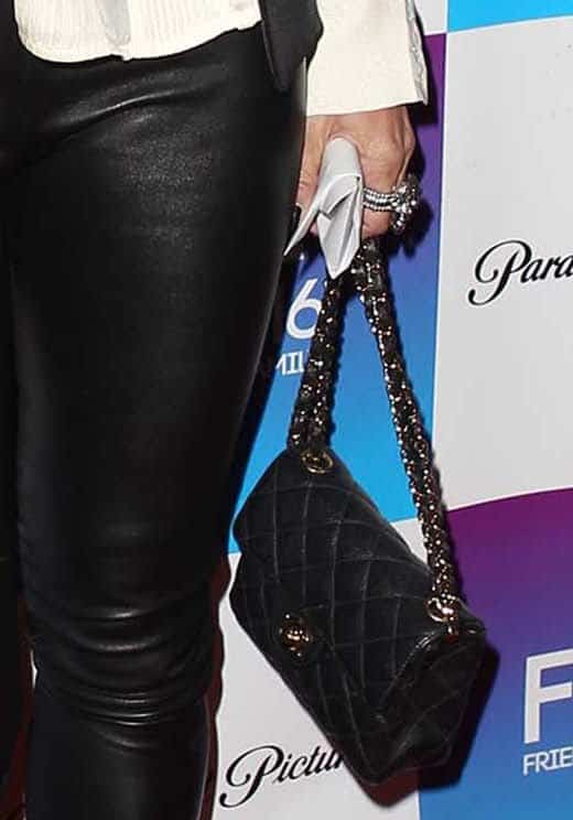 Robin Antin’s quilted black bag, likely Chanel, channels timeless sophistication and pairs effortlessly with her sharp black-and-white look