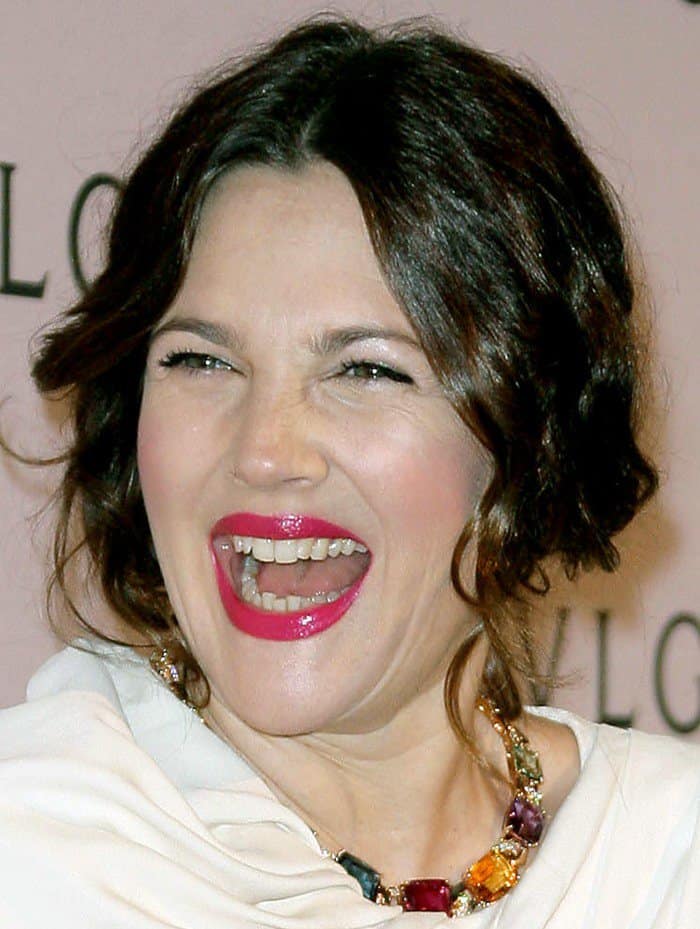 Drew Barrymore's radiant smile complements her chic look at the BVLGARI celebration for Elizabeth Taylor