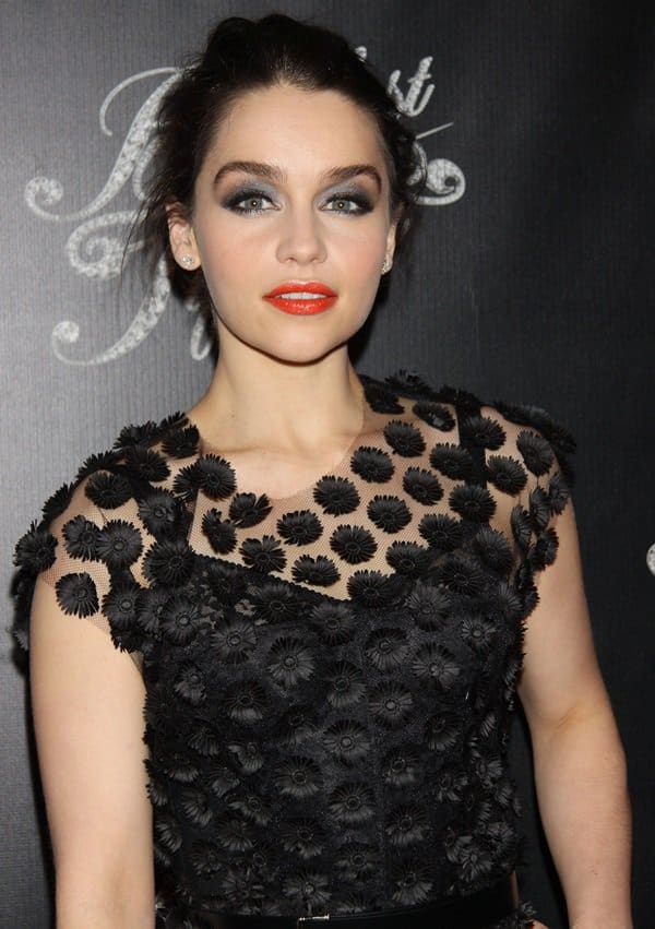 Emilia Clarke's makeup was bold and striking, with heavy, shimmering silver-and-black eye makeup paired with an orange lip, giving an edgy finish to her sophisticated attire