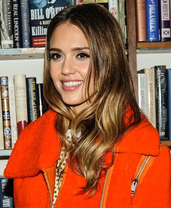 Jessica Alba's vibrant fashion statement in a bright orange Fendi moto jacket during her book signing event