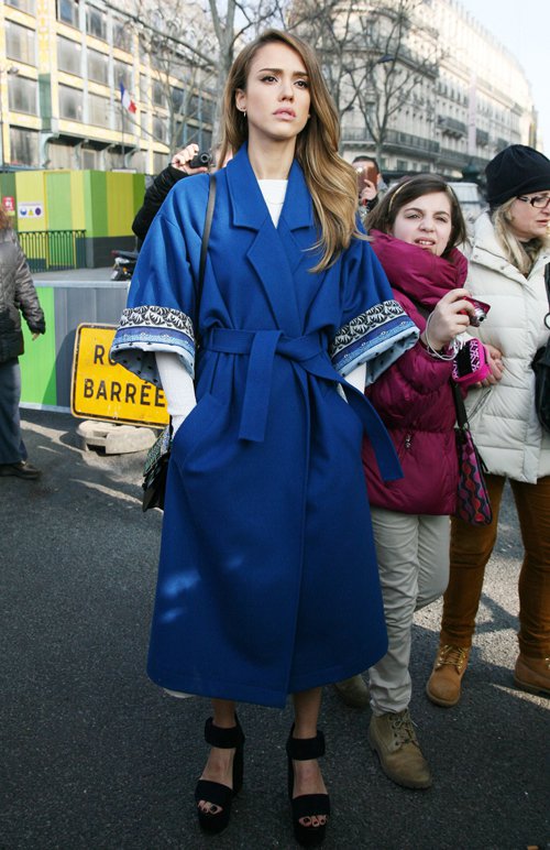 Jessica Alba stuns in a vibrant blue kimono-style coat paired with platform sandals, effortlessly blending elegance and modern style during Paris Fashion Week