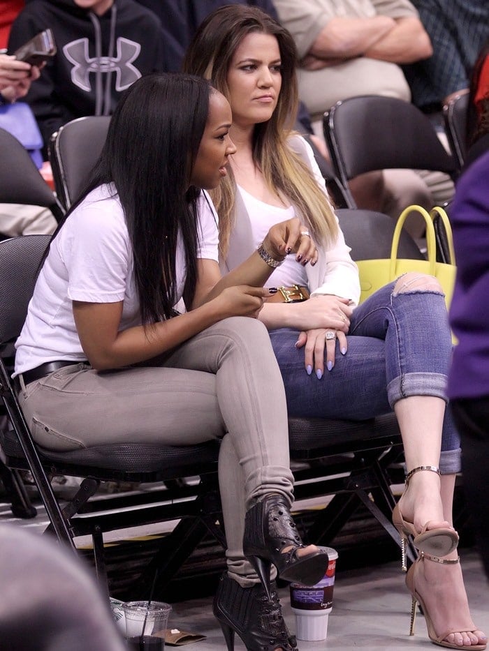 Khloé Kardashian talks with her best friend Malika Haqq at a basketball game