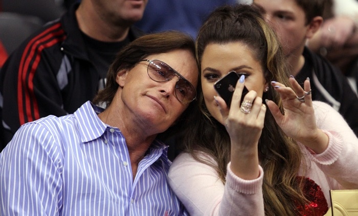 Khloé Kardashian takes a selfie with Bruce Jenner while sitting courtside
