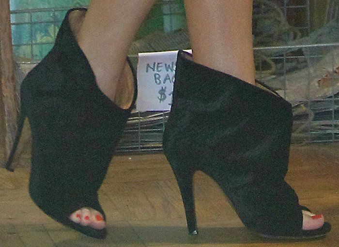 Khloé Kardashian steps out in sleek black Maison Martin Margiela open-toe booties, showcasing the brand’s signature sculptural shape and minimalist edge
