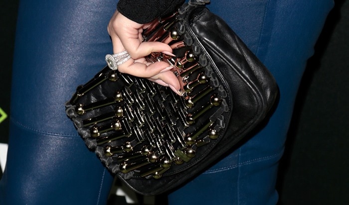 Khloé Kardashian's edgy clutch, statement ring, and sleek manicure add a bold touch to her look