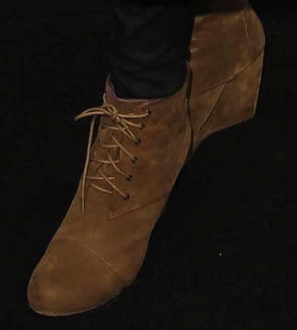 Lisa Leslie is wearing a pair of suede lace-up wedge booties in a warm beige tone