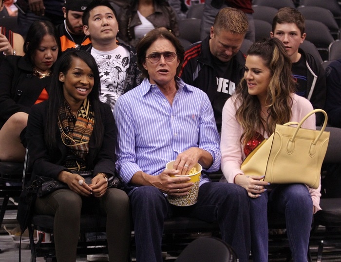 Malika Haqq, Bruce Jenner, and Khloé Kardashian pose for a picture while at the game, showcasing their distinct personal styles
