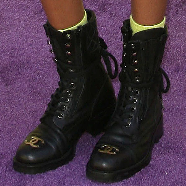 Willow Smith pairs neon yellow socks with black lace-up Chanel combat boots, detailed with the brand’s iconic gold CC logo at the toe