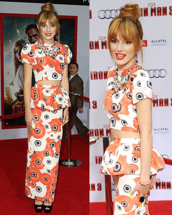 Bella Thorne turns heads in a vibrant Katie Ermilio two-piece ensemble, featuring bold floral patterns, a peplum top, and a matching floor-length skirt, accessorized with statement jewelry and a chic updo