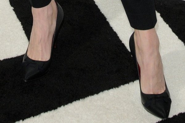 A closer look shows her black pointed-toe pumps with bow detailing, adding a soft contrast to the structured outfit
