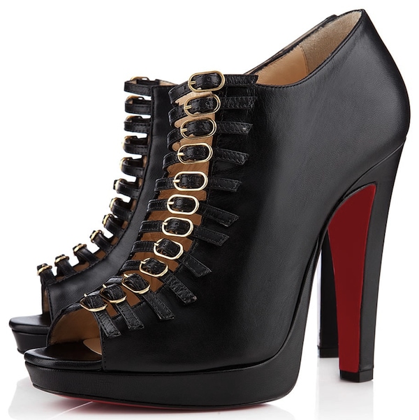 Christian Louboutin's black "Manon" booties combine a cage-like arrangement of slim buckle straps with peep toes, hidden platforms, and signature red soles for a bold, architectural take on evening footwear