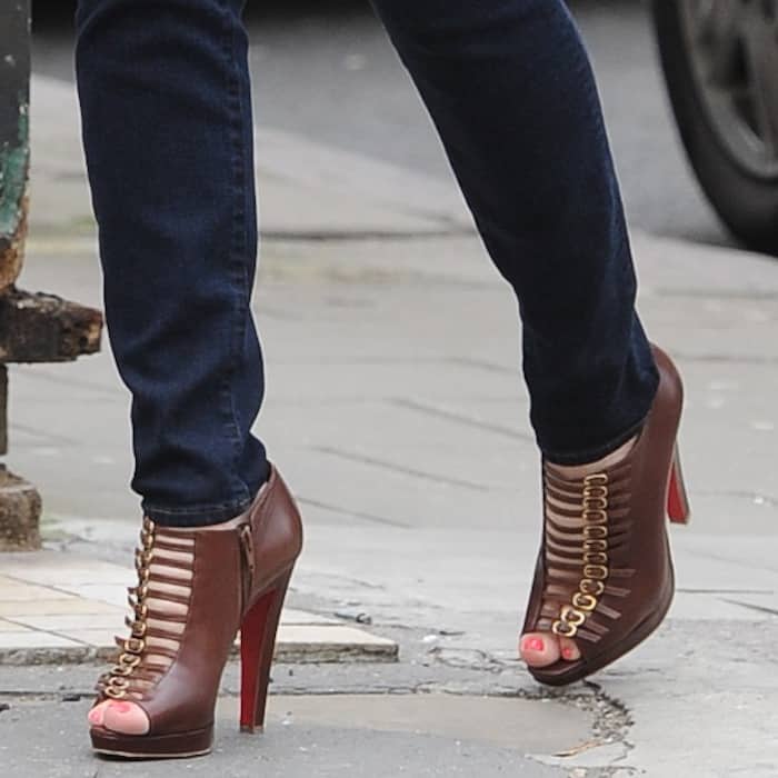 Kelly Brook steps out in brown Christian Louboutin "Manon" booties, showcasing the style's signature buckle straps, peep toes, and towering red-soled heels