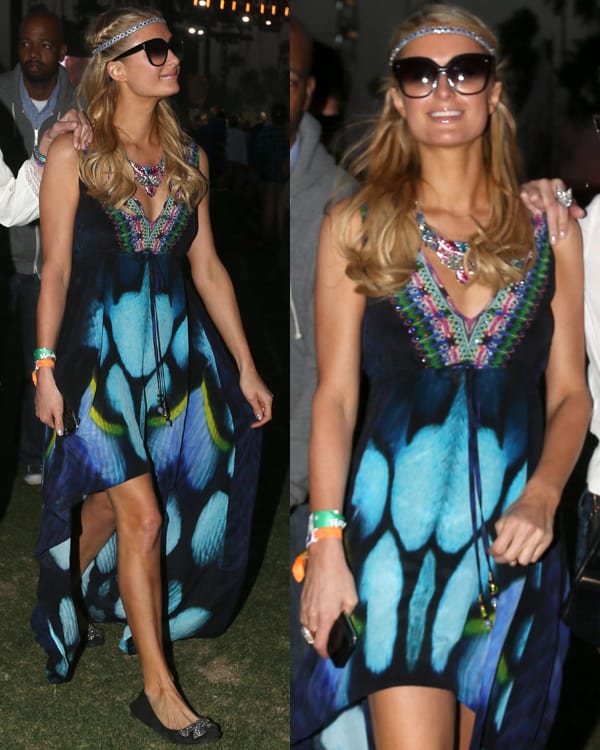 Paris Hilton channels a bohemian vibe with a delicate braid-style headband woven through her long, wavy blonde hair, perfectly complementing her vibrant, flowing high-low dress