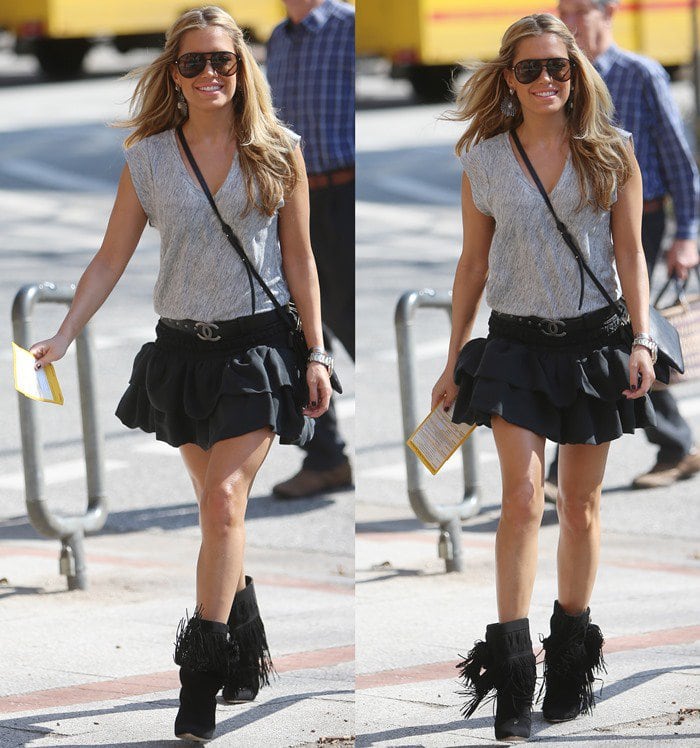 Sylvie van der Vaart wears a black skirt and gray t-shirt with a Chanel belt while shopping in Germany