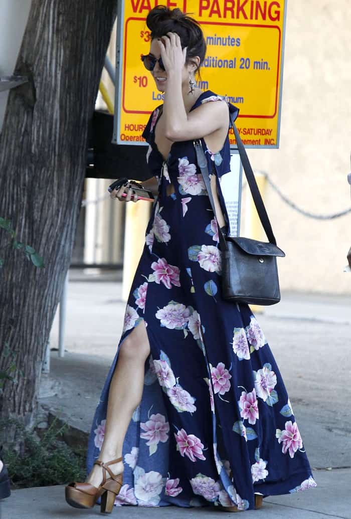 Vanessa Hudgens paired a navy floral cutout maxi dress with brown leather Koolaburra "Starla" platform clogs, using the chunky wooden heels to balance the dress's flowing silhouette during a stroll in West Hollywood