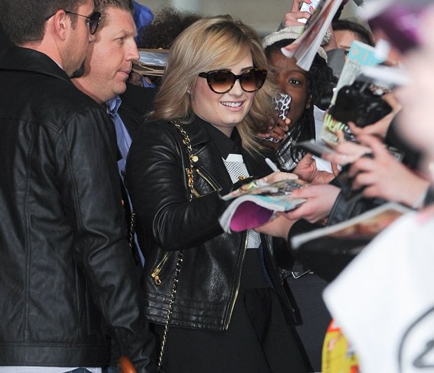 Demi Lovato stops to sign autographs outside BBC Radio 1, giving fans a closer look at the layered Rag Bone outfit that defined her polished off-duty style during the Demi promotion