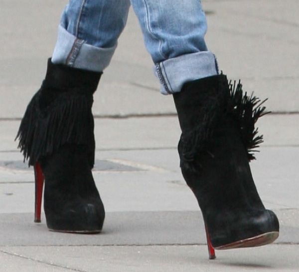 Kate Moss effortlessly showcases her edgy yet chic aesthetic in Christian Louboutin 'Rom' fringed suede ankle boots, perfectly paired with cuffed jeans for a laid-back yet stylish look