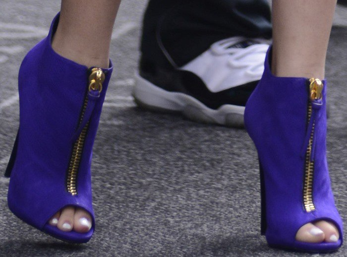 Zendaya's chic peep-toe Giuseppe Zanotti booties, with their striking gold zipper detail, perfectly showcase her polished white pedicure