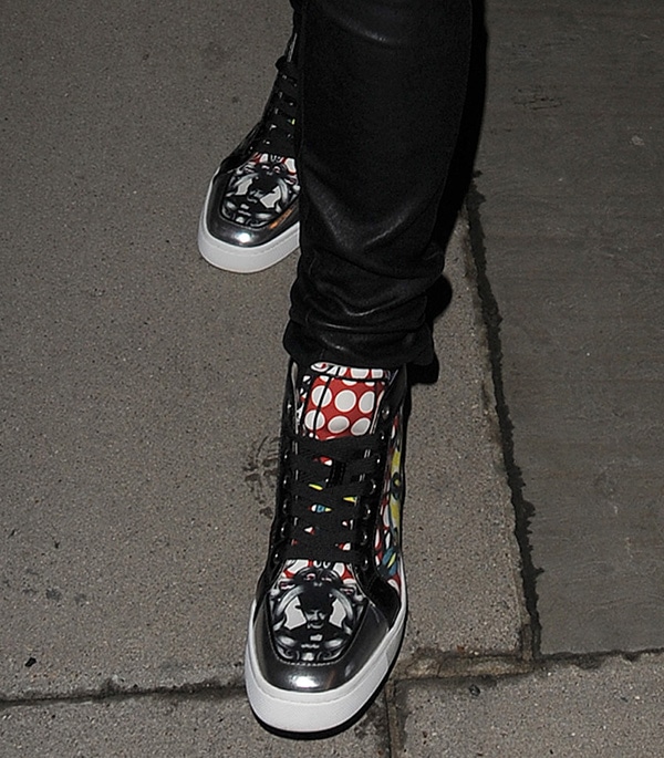 A closer look at Rita Ora’s Christian Louboutin “Rantus Orlato” sneakers, featuring multicolored graphic prints, metallic accents, and black patent trim