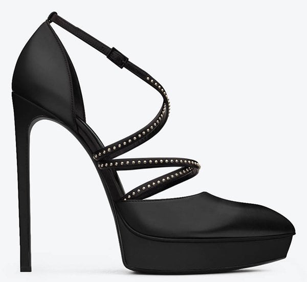 The Saint Laurent “Janis” studded platform pump features sleek crisscross straps, a beveled platform, and a towering stiletto heel