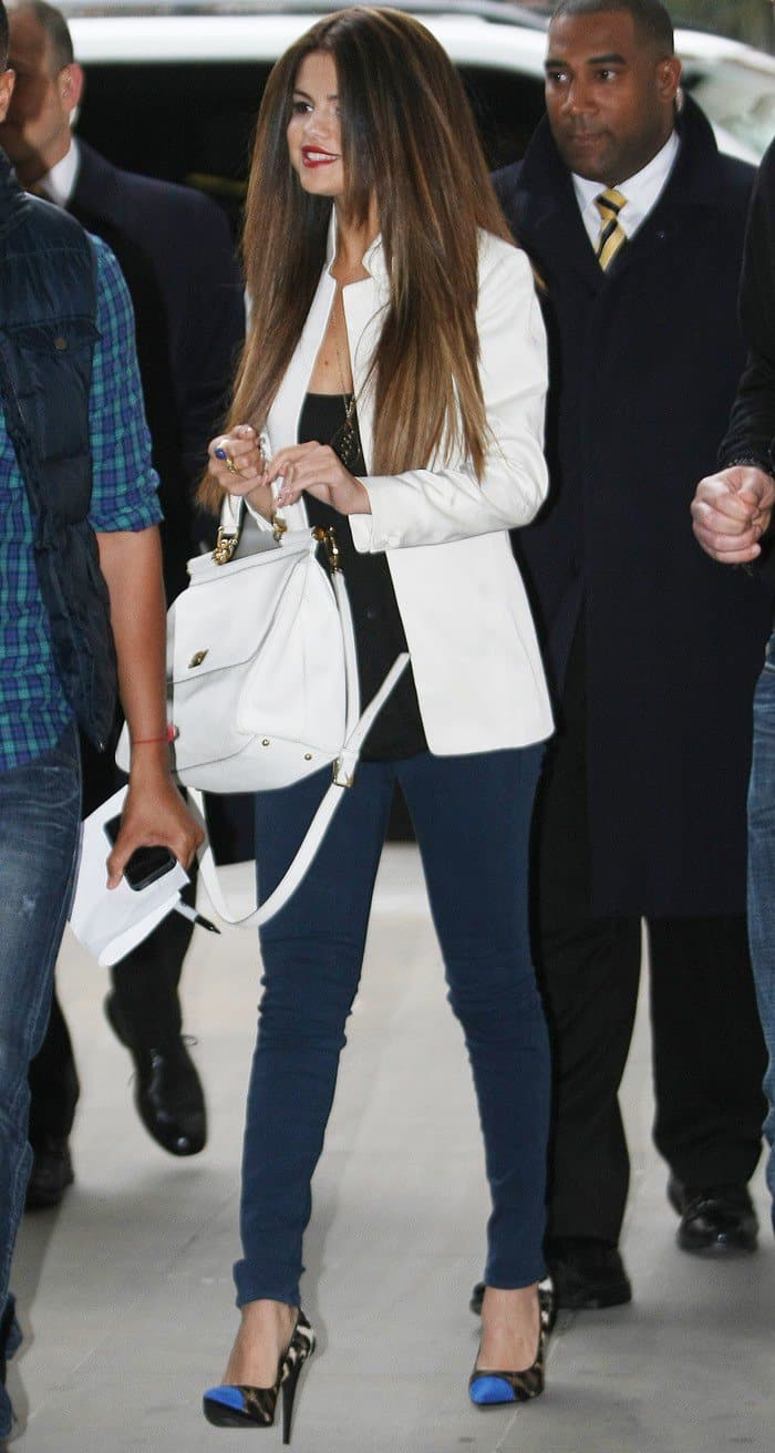 Selena Gomez shows how to elevate a chic casual look by pairing teal skinny jeans with a structured white blazer, leopard cap-toe pumps, and a classic white Dolce Gabbana bag