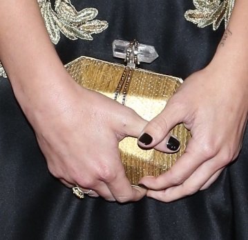 Ashley Greene complemented her elaborate gold-embellished Marchesa gown with a stunning gold hard case clutch at the Met Gala