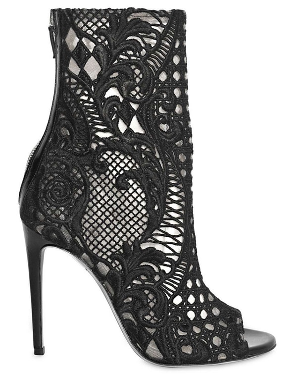 Balmain’s “Guipure” Lace Open-Toe Boots ($1,885) feature intricate cutout lacework, sleek patent trim, and a towering stiletto heel for a statement-making finish