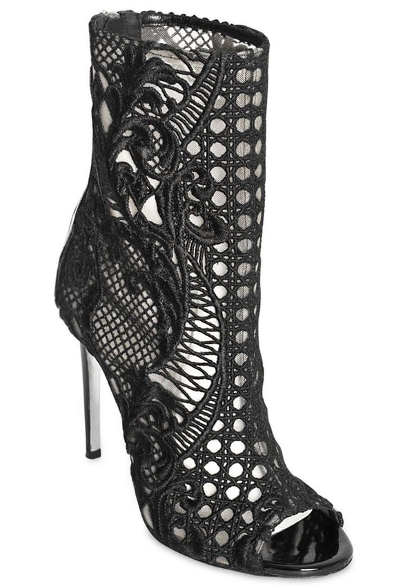 Balmain’s “Guipure” Lace Open-Toe Boots ($1,885) feature intricate cutout lacework, sleek patent trim, and a towering stiletto heel for a statement-making finish