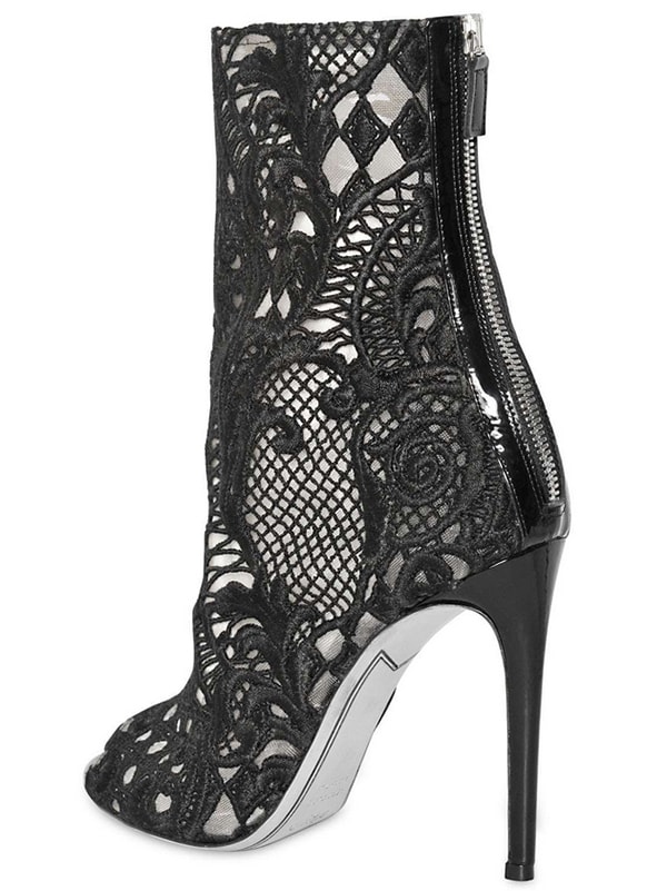 Balmain’s “Guipure” Lace Open-Toe Boots ($1,885) feature intricate cutout lacework, sleek patent trim, and a towering stiletto heel for a statement-making finish