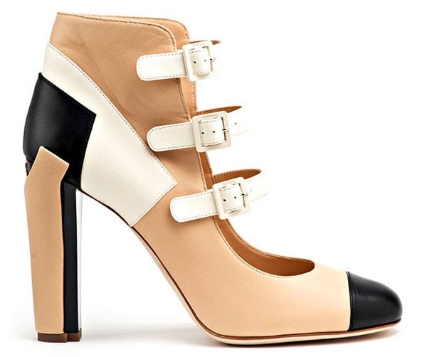 A clean product shot showcases the full design: supple tan leather, crisp white straps, and Chanel’s iconic black toe cap reimagined in a modern, color-blocked composition