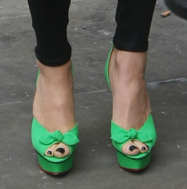 Jessie J elevates her look with Charlotte Olympia's Serena heels, featuring peep toes, transparent ankle straps, and a classic bow detail on crepe de chine fabric