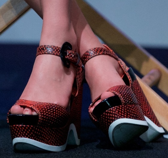 AnnaSophia Robb showcases her bold style with these striking snakeskin-textured platform wedges featuring bright orange accents and a modern, chunky design at the SoHo event