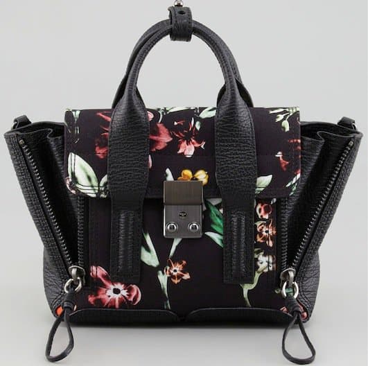 Hilary Rhoda's compact 3.1 Phillip Lim Pashli mini satchel in black pebbled leather, accented with a bold floral print and signature front-lock hardware for a polished yet modern finish