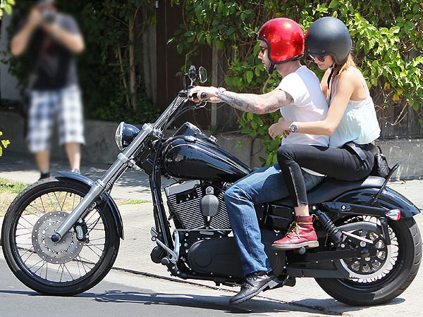 Adam Levine and Behati Prinsloo, wearing casual summer looks with Behati in cuffed black skinny jeans and red wedge sneakers, ride a motorcycle after lunch at Mustard Seed Cafe in Los Feliz on August 7, 2012