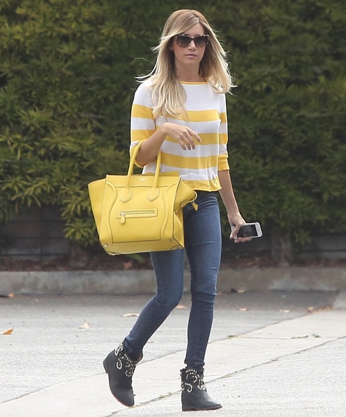 On July 24, 2013, in Santa Monica, Ashley Tisdale styled a casual look with a Lark Wolff by Steven Alan stripe boatneck sweater, Isabel Marant Caleen studded boots, Gucci 3502 sunglasses, and a Celine Boston Bag