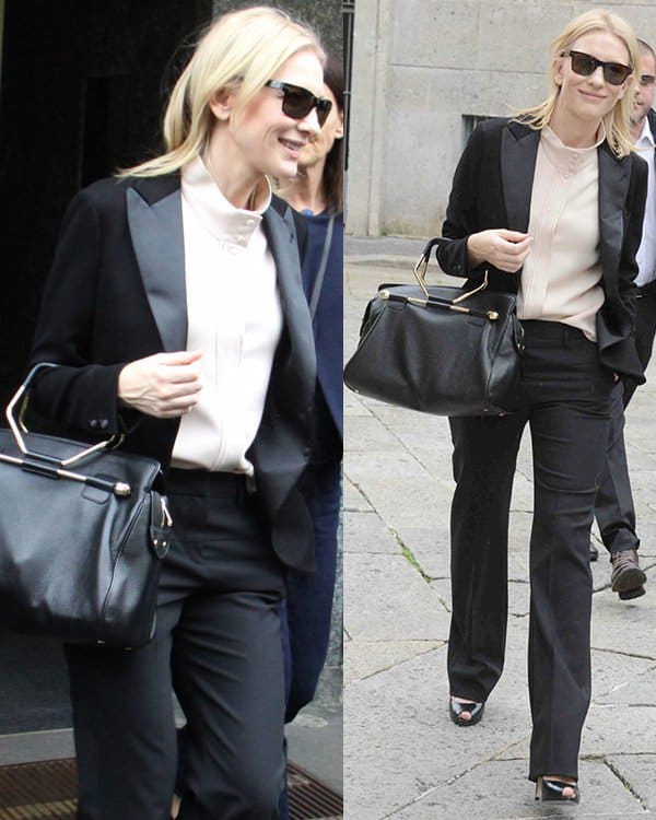 Cate Blanchett showcased her flair for power dressing in Milan, Italy, opting for a masculine-inspired black two-piece suit with a high-necked cream blouse, complemented by leather details on the blazer lapels, wide-leg trousers, dark shades, an oversized Viktor  Rolf black leather handbag, and patent peep-toe heels