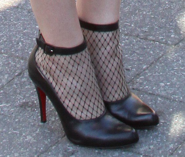Hailee Steinfeld’s Christian Louboutin “Resillissima” booties feature a daring fishnet mesh and glossy leather trim, showing off the brand’s signature red soles