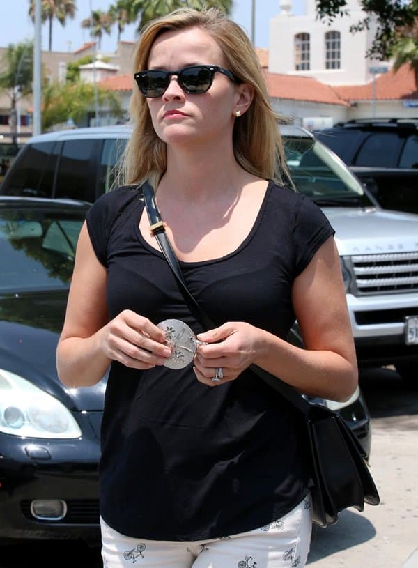 Caught on camera, Reese Witherspoon heads to Divino in Brentwood showcasing a chic black top and trendy sunglasses, July 18, 2013